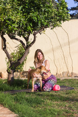 Young woman playing with her dog in garden - 337863789