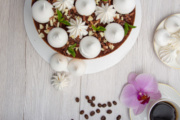 Delicious brown cake with marshmallows and a cup of coffee