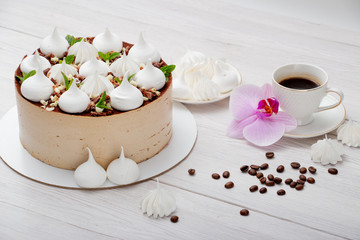 Delicious brown cake with marshmallows and a cup of coffee