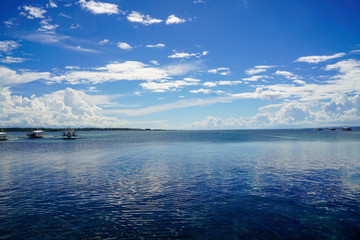 blue calm seascape, horizon, ocean, boats in the background, cloudy sky, tropical travel, contrasting wallpaper                               