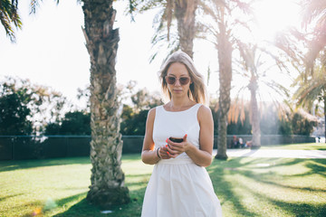 Stylish woman using smartphone in park