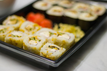 japanese cuisine different rolls with black chopsticks red pickled ginger wasabi sauce and soy sauce on the table