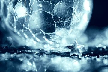 Macro photo of bright silver star and cracked glass sphere