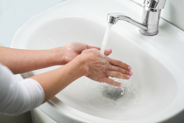 Woman washing hands with soap