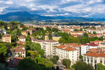 Obraz premium Aerial view of Bergamo city, Lombardy, Italy. Picturesque spring view from one of the viewpoints in Bergamo old town. European Alps on the background