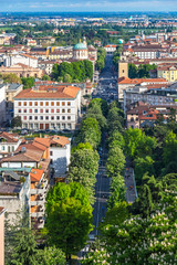 Fototapeta na wymiar Aerial panorama of Bergamo city, Lombardy province, Italy. Picturesque spring view of Bergamo main street, Viale Vittorio Emanuele II. Bergamo railway station on the background