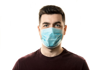 Theme of coronavirus and safety. A young man in a blue mask from a virus. Horizontal frame