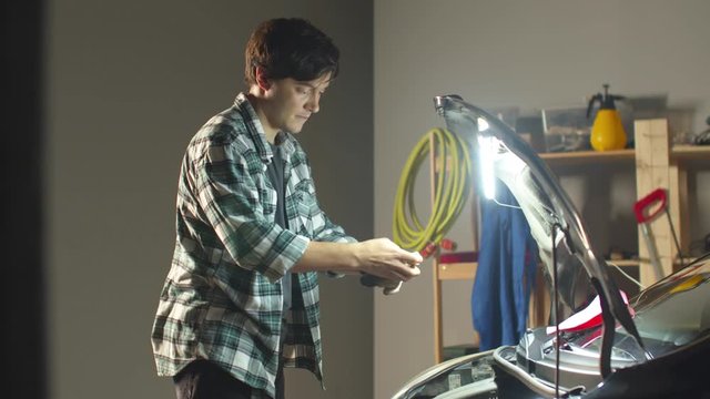 Auto mechanic puts on work gloves. Dirty work. 
