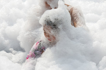 Close-up of a cute Asian girl smiling in a Foam Party at the outdoor pool.