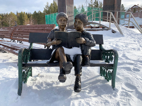 Zlatoust, Chelyabinsk region, Russia, January, 19, 2020. Sculpture "Couple reading on a bench" in the mountain Park named after P. P. Bazhov on Red hill in winter. The city of Zlatoust
