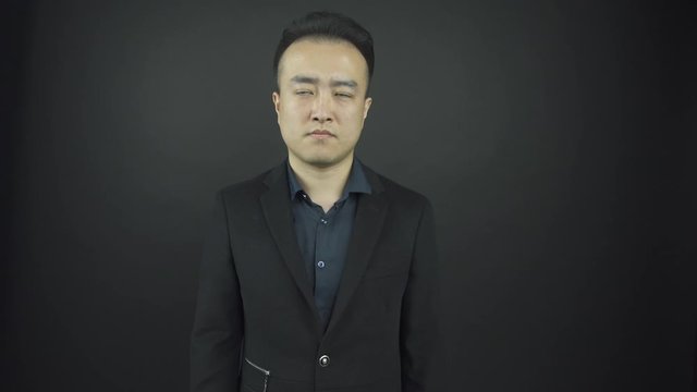 serious man in blue shirt under stylish suit jacket poses
