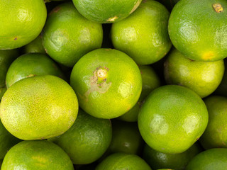 Fresh ripe limes, top view of green lemon background
