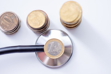 Stethoscope With Stacked Coin on white background, checkup Covid-19