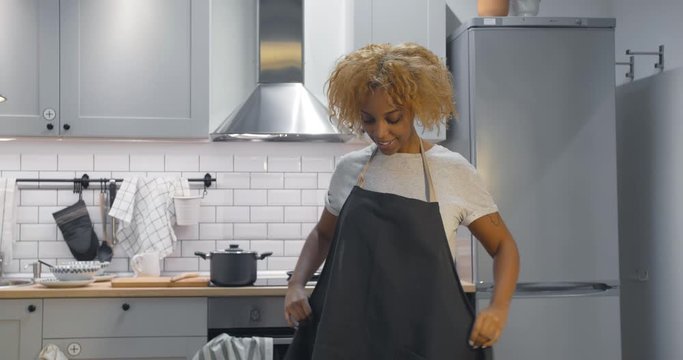 African woman put on apron before start cooking