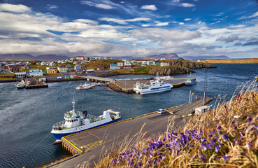 Beautiful panoramic view of the Stykkisholmskirkja Harbor with Fishing ships (boats) at Stykkisholmur town in western Iceland. City view from Sugandisey Cliff with lighthouse. Famous colorful houses