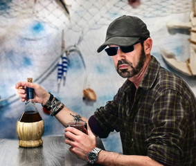 hombre de mar tomando vino en la cantina del puerto