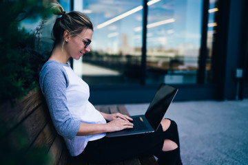 Smiling freelancer using on bench