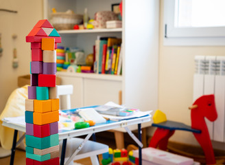 Bright colorful wooden blocks toy. Bricks building tower, castle, children's room as a background