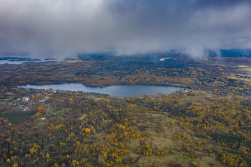 Drone view point of rural area in Autumn with lake Boroye, The big wooden house in forest, Piers on the lake, Valday national park, Russia, panoramic image, golden trees, Wooden lodges, cloudy weather
