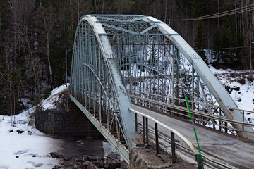 Umea, Norrland Sweden - March 15, 2020: an arched metal bridge over the river in winter time