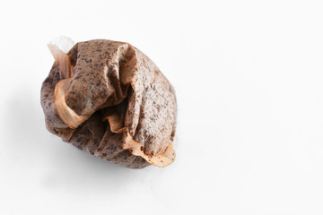 A close up image of a single used teabag on a white background. 