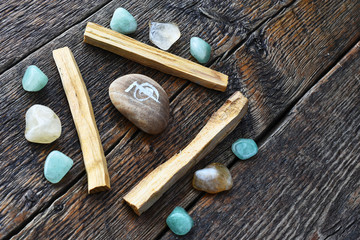 A close up image of three palo santo smudge sticks with green aventurine and citrine healing crystals. 