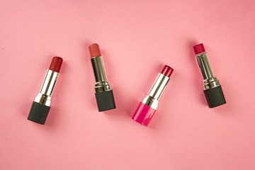 Obraz premium lipstick on a pink background, the concept of decorative cosmetics for the face, visage and facial care, a female product, top view, for the cosmetic department of the store