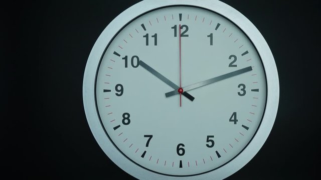 Close up Move the camera angle from right to left, Ten o'clock Gray wall watch on black background, Time lapse 60 minutes moving fast, Time concet.