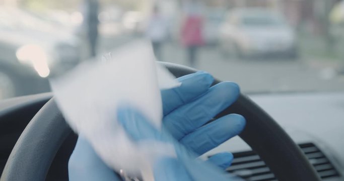 Wiping and disinfecting car key hands in gloves covid 19 pandemic