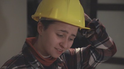 A Woman In Wearing Long Sleeves Polo Shirt Put The Yellow Hard Hat In Her Head. -close up shot - Powered by Adobe