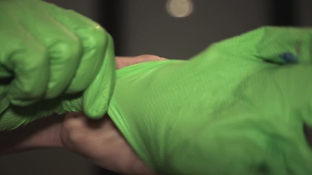 A Person Wearing Green Gloves In His Right Hand - Closeup Shot