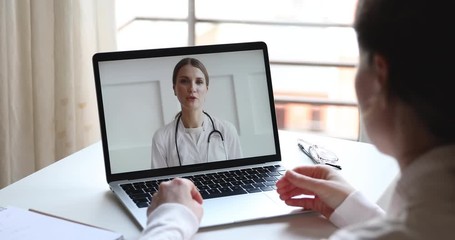 Telemedicine videoconference concept. Friendly female doctor consulting woman client patient by video call remote healthcare web cam app chat on laptop. Over shoulder closeup computer screen view - Powered by Adobe
