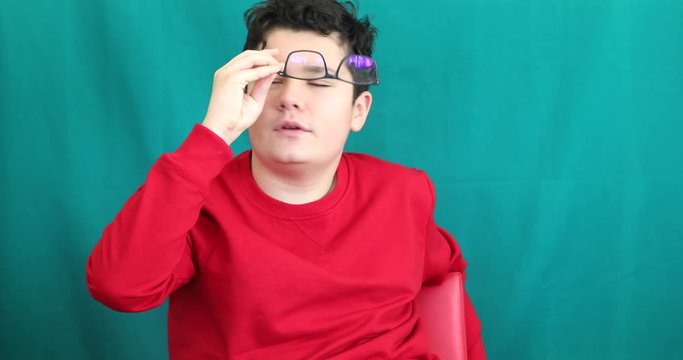 Portrait of a happy teenage boy making funny grimace gainst chroma key green screen background