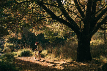 Young attractive walking with a dog in the park Oamaru, New Zealand.