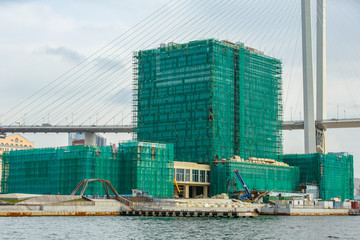 A five-star Hyatt hotel on the Ship Embankment of Vladivostok surrounded by scaffolding. Sea face of Vladivostok