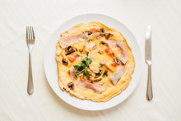 Homemade beaten eggs soft omelette.Colorful healthy breakfast at home.Home cooked meal served.Low calorie food,low carb lifestyle eating in.Keto meal.Delicious colorful basic French omelet recipe.