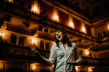 Entertainer performing on a stage in a empty theater,concert hall without fans.No audience.COVID-19 canceled show.Opera house without spectators.Entertainment industry crisis.Streaming theater