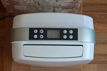 The control panel with the buttons on the dehumidifier in the room close up