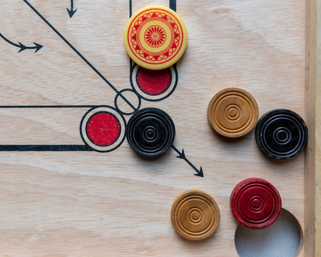 Carom board with striker and carom men. Selective focus.