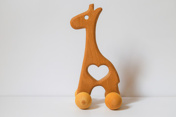 children's wooden toy giraffe with wheels on a white background