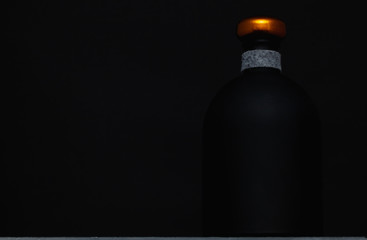 Empty bottle of whiskey on the black background.