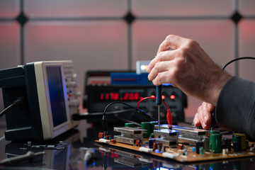 Debugging electronics device. PCB witch microcontroller in electronics laboratory