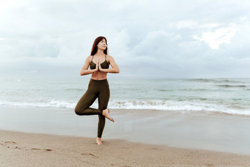 yoga beach woman doing pose at the ocean for zen health and peaceful lifestyle