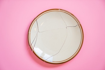 Broken plate on pink background