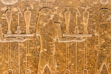 Ancient egyptian paintings and hieroglyphs carved on the stone wall