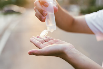 Asian man using alcohol antiseptic gel and wearing mask,prevent against infection of Covid-19 outbreak,woman washing hands with hand sanitizer to avoid contaminating with Corona virus