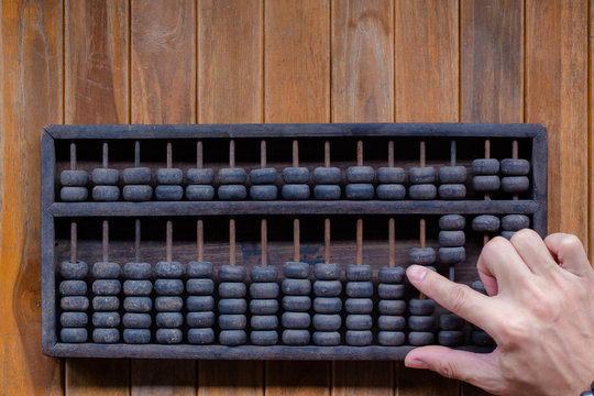 Old Vintage tone of Man's hands accounting with old abacus and hold electronic calculator. picture financial concept design.