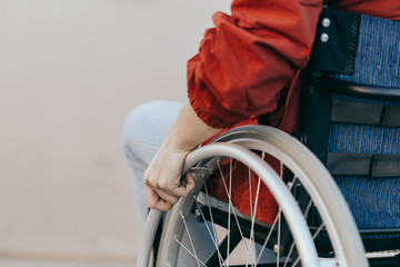 Close up of a young woman in a wheelchair while walking in a park on a sunny day. Recovery and...