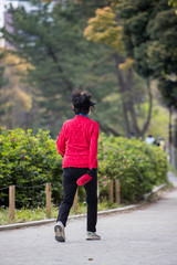 朝の公園でジョギングしている高齢女性