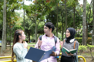 Young asian malay chinese man woman outdoor park walk stand study talk discuss point laptop file...